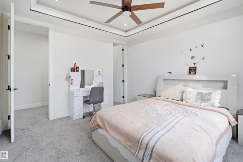 Interior room featuring light gray carpet flooring, white walls, and a tray ceiling with recessed lighting and a ceiling fan - 304 33 Avenue Nw, Edmonton, AB - Indoor Photo Showing Bedroom