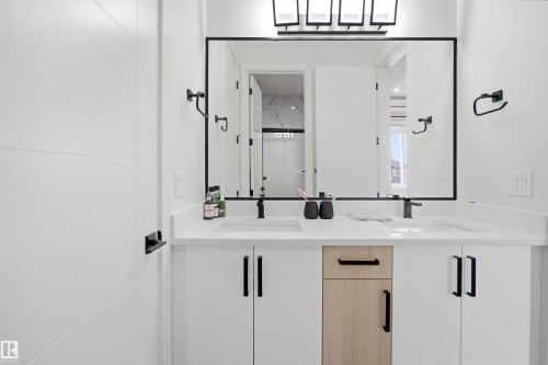 Dual vanity with integrated sinks, white countertops, and matte black fixtures - 304 33 Avenue Nw, Edmonton, AB - Indoor Photo Showing Bathroom