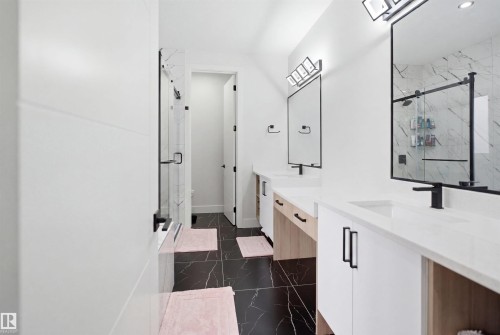 Modern bathroom featuring dual vanities with white countertops, integrated sinks, and matte black fixtures - 304 33 Avenue Nw, Edmonton, AB - Indoor