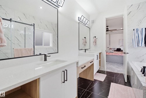 Dual vanity bathroom featuring black marble-patterned floor tiles and white marble-patterned wall tiles - 304 33 Avenue Nw, Edmonton, AB - Indoor Photo Showing Bathroom