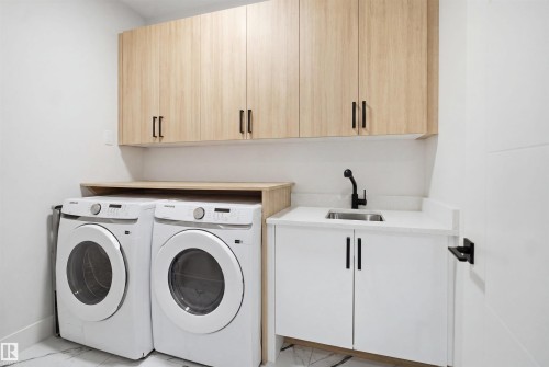 Laundry area featuring wood-finish cabinetry, white countertop, stainless steel sink, and a matte black faucet - 304 33 Avenue Nw, Edmonton, AB - Indoor Photo Showing Laundry Room