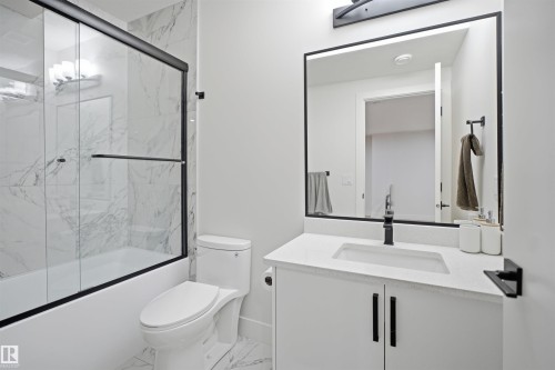 Modern bathroom featuring a white vanity with integrated sink, quartz countertop, and matte black faucet - 304 33 Avenue Nw, Edmonton, AB - Indoor Photo Showing Bathroom