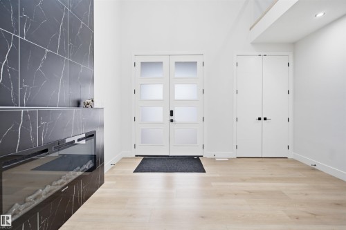 Striking black marble-effect fireplace with a modern electric insert - 304 33 Avenue Nw, Edmonton, AB - Indoor Photo Showing Other Room