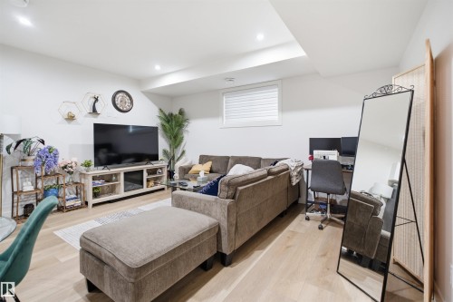 Bright living space featuring wood-finish flooring, recessed lighting, and a window with blinds - 304 33 Avenue Nw, Edmonton, AB - Indoor