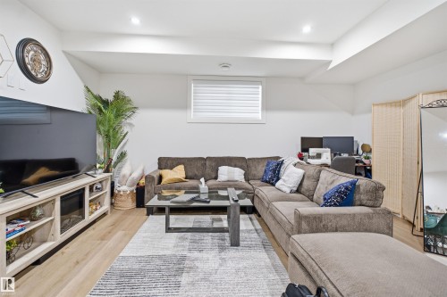 Recessed lighting illuminates this versatile living area featuring light wood-finish flooring - 304 33 Avenue Nw, Edmonton, AB - Indoor Photo Showing Living Room