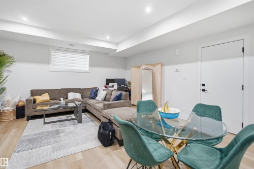Open-concept room featuring light wood-finish flooring, recessed lighting, and a white interior door with matte black hardware - 304 33 Avenue Nw, Edmonton, AB - Indoor Photo Showing Other Room