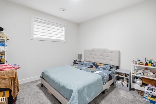 Carpeted room with a tufted headboard, a window with blinds, and white walls - 304 33 Avenue Nw, Edmonton, AB - Indoor Photo Showing Bedroom