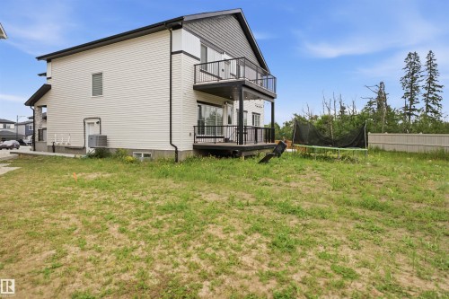 Two-story siding exterior with a second-floor balcony featuring black railings - 304 33 Avenue Nw, Edmonton, AB - Outdoor