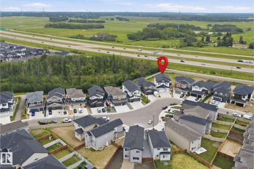 Aerial view of a residential cul-de-sac with diverse modern architecture, dark-shingle roofs, and concrete driveways - 304 33 Avenue Nw, Edmonton, AB - Outdoor With View