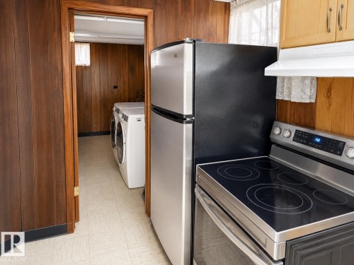 Kitchen area featuring a stainless steel refrigerator and electric range with a glass cooktop - 7812 144 Avenue Nw, Edmonton, AB - Indoor