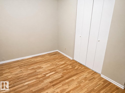 Neutral-toned walls complementing wood-finish flooring - 7812 144 Avenue Nw, Edmonton, AB - Indoor Photo Showing Other Room