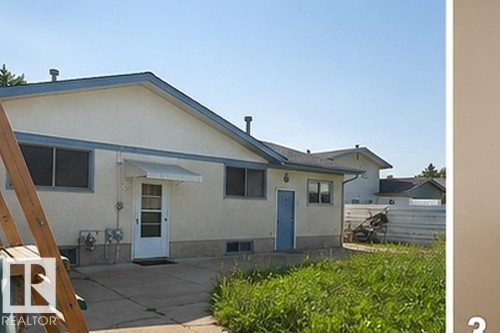 Rear exterior showcasing stucco siding and a blue trim accent - 7812 144 Avenue Nw, Edmonton, AB - Outdoor