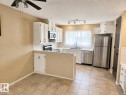 Kitchen featuring white cabinetry, tile flooring, stainless steel appliances, white countertops, and a ceiling fan - 7812 144 Avenue Nw, Edmonton, AB  - Indoor Photo Showing Kitchen 