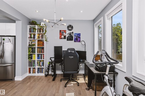 Open-concept space featuring wood-finish flooring, light gray walls, and multiple windows with white trim - 11305 79 Avenue Nw, Edmonton, AB - Indoor