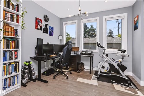 Bright room featuring three large windows, recessed lighting, and wood-finish flooring - 11305 79 Avenue Nw, Edmonton, AB - Indoor