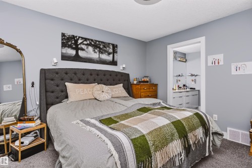 Carpeted bedroom with a built-in wall niche, neutral wall color, and white trim - 11305 79 Avenue Nw, Edmonton, AB - Indoor Photo Showing Bedroom