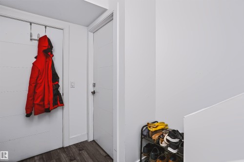 Entryway featuring wood-finish flooring, white doors with modern horizontal detailing, and sleek white walls - 11305 79 Avenue Nw, Edmonton, AB - Indoor Photo Showing Other Room