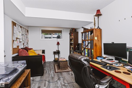 Versatile room featuring wood-finish flooring, a functional window, and bright white walls - 11305 79 Avenue Nw, Edmonton, AB - Indoor Photo Showing Office