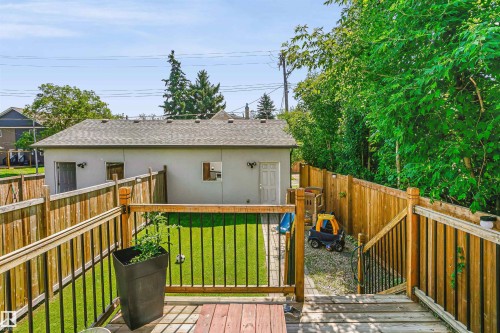 Expansive backyard featuring a multi-level wood deck, artificial turf lawn, and a detached structure with a shingled roof - 11305 79 Avenue Nw, Edmonton, AB - Outdoor With Deck Patio Veranda With Exterior