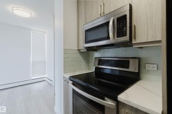 Contemporary kitchen with wood-finish cabinetry, stainless steel appliances, and a light-toned countertop - 