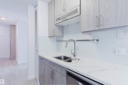Kitchen area featuring light wood-finish cabinetry, white countertop, and white subway tile backsplash - 