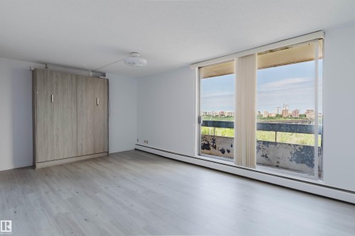 Bright living space featuring light wood-finish flooring and a built-in wall bed - #303 10883 Saskatchewan Dr Nw, Edmonton, AB - Indoor Photo Showing Other Room