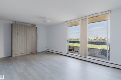 Bright living space featuring light wood-finish flooring and a built-in wall bed - 