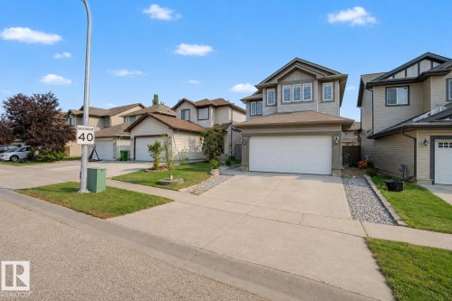 Two-story home with light gray siding, dark trim, a two-car garage, and concrete driveway - 5 Cypress Link, Fort Saskatchewan, AB - Outdoor With Facade