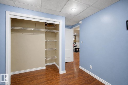 Closet with white wire shelving and hanging rod set against wood-finish flooring - 5 Cypress Link, Fort Saskatchewan, AB - Indoor Photo Showing Other Room