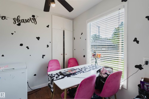 Room featuring a window with blinds, ceiling fan with light fixture, built-in white cabinetry, and wood-finish flooring - 10955 72 Avenue Nw, Edmonton, AB - Indoor