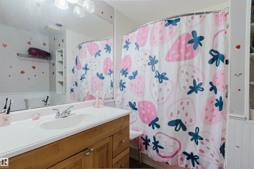 Bathroom with a wood-finish vanity, a white countertop, and a built-in sink - 10955 72 Avenue Nw, Edmonton, AB - Indoor Photo Showing Bathroom