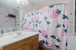 Bathroom with a wood-finish vanity, a white countertop, and a built-in sink - 