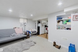 Brightly lit interior space featuring recessed ceiling lights, an integrated wall niche with shelving, and light-colored carpeting - 