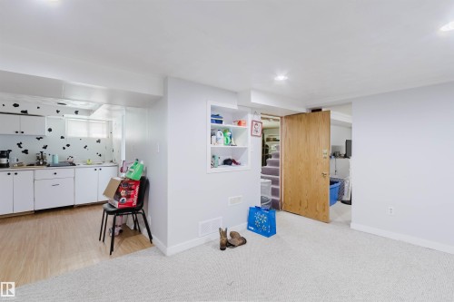 Lower level featuring a kitchenette with white cabinetry and wood-finish flooring - 10955 72 Avenue Nw, Edmonton, AB - Indoor