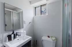 Bathroom featuring a vanity with a white basin sink, framed mirror, and a window - 