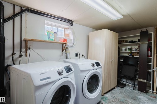 Dedicated laundry area featuring a window, overhead fluorescent lighting, and a wall-mounted shelving unit - 10955 72 Avenue Nw, Edmonton, AB - Indoor Photo Showing Laundry Room