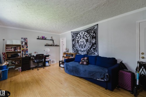 Spacious interior room featuring light wood-finish flooring, white trim, and light-colored walls - 10955 72 Avenue Nw, Edmonton, AB - Indoor