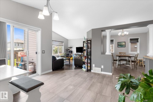 Open concept living area featuring wood-finish flooring, a sliding glass door to the exterior, and vaulted ceilings - 4009 158 Avenue Nw, Edmonton, AB - Indoor