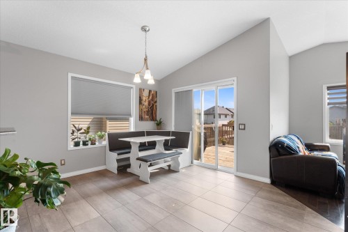 Dining area featuring vaulted ceilings, light gray wall paint, and a modern chandelier - 4009 158 Avenue Nw, Edmonton, AB - Indoor Photo Showing Living Room