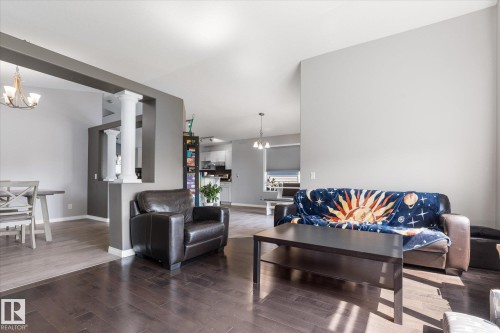 Living space featuring dark wood-finish flooring, light grey painted walls, and a vaulted ceiling - 4009 158 Avenue Nw, Edmonton, AB - Indoor Photo Showing Living Room