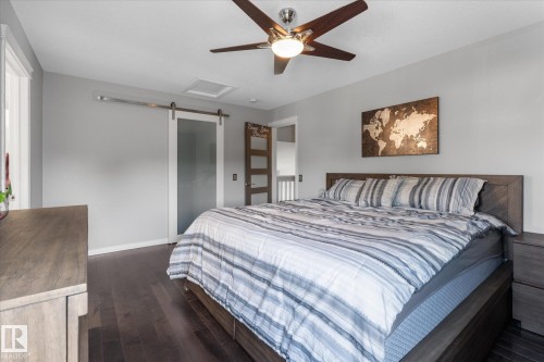 Wide plank wood-finish flooring with a dark stain - 4009 158 Avenue Nw, Edmonton, AB - Indoor Photo Showing Bedroom