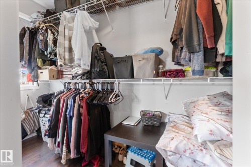 Customizable closet system featuring wire shelving, multiple hanging rods, and dark wood-finish flooring - 4009 158 Avenue Nw, Edmonton, AB - Indoor With Storage