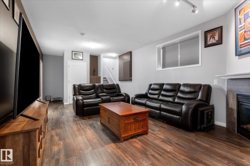 Spacious entertainment area featuring wood-finish flooring, a fireplace with a mantel, and recessed lighting - 4009 158 Avenue Nw, Edmonton, AB - Indoor Photo Showing Living Room With Fireplace