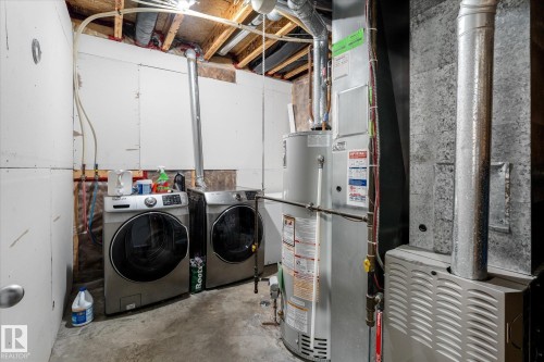 Dedicated utility area featuring a water heater, furnace, and exposed ductwork - 4009 158 Avenue Nw, Edmonton, AB - Indoor Photo Showing Laundry Room
