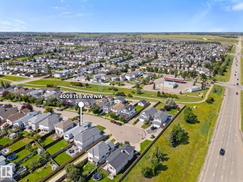 Aerial perspective showcasing a residential neighborhood with green spaces and a commercial intersection - 4009 158 Avenue Nw, Edmonton, AB - Outdoor With View