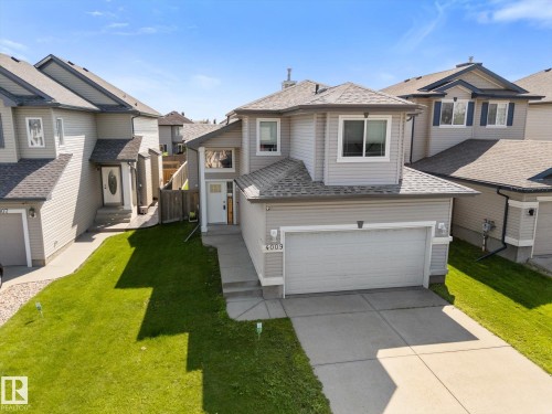 Two-story residence featuring light gray siding with white trim, a gabled roofline, and an attached front-facing garage - 4009 158 Avenue Nw, Edmonton, AB - Outdoor With Facade