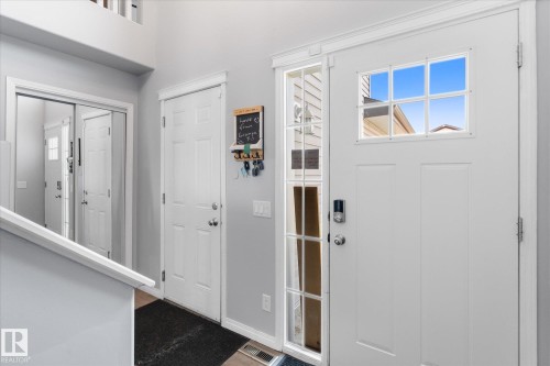 Entryway featuring a white paneled front door with a multi-pane glass insert and a digital lock - 4009 158 Avenue Nw, Edmonton, AB - Indoor Photo Showing Other Room