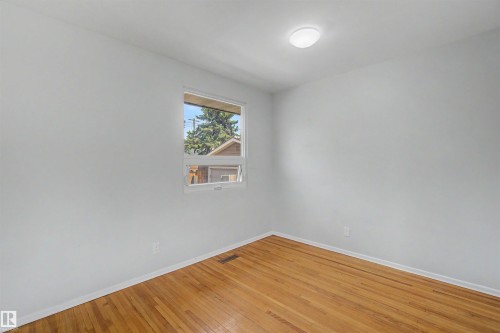 Room featuring light wood-finish flooring, white walls, and a single window with white trim - 8215 149 Street Nw, Edmonton, AB - Indoor Photo Showing Other Room