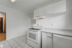Kitchen featuring white tile flooring, white cabinetry, solid surface countertops, a white electric range, and a white dishwasher - 