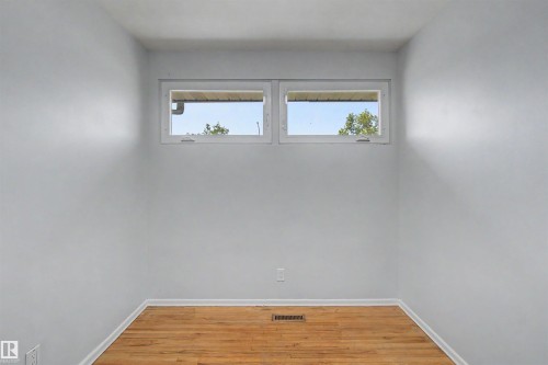 Room with light gray walls, wood-finish flooring, and white baseboards - 8215 149 Street Nw, Edmonton, AB - Indoor Photo Showing Other Room